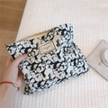 Detail of leaf print cotton makeup bag featuring a vintage label and gold metal zipper - Black with Leaves