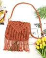 Detailed flat lay of bohemian brick-red macrame crossbody bag with long fringes and strap - Orange Red