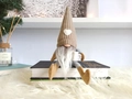 Gebreide kerstkabouter op boeken met dennentakken voor een gezellige woondecoratie - Khaki Man