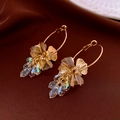 Dettaglio di orecchini a fiore dorati con nappe di cristallo scintillanti su raso - Pendente a Goccia d'Acqua con Fiore Cavo Oro (17# Perno in Argento)
