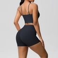 Side view of black yoga set featuring thin strap sports bra and high waist shorts - Black