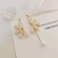 Detail van asymmetrische lange bloembladoorbellen met gouden kettingen en witte parel - Asymmetrische Bloem (Oorsteker)