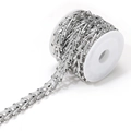 Vue macro d'une chaîne géométrique en acier argenté sur une bobine en plastique - Chaîne Faite Main Type Échelle 12mm de Large 4,5mm d'Épaisseur