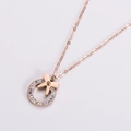 Collana con ciondolo a fiocco in oro rosa con zirconi lucidi su sfondo bianco - Oro rosa