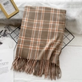 Brown and orange checkered cashmere scarf with tassels on a metal grid background - Camel