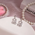 Gros plan détaillé de boucles d'oreilles ours en argent avec strass brillants et perles - Ours Creux Argenté