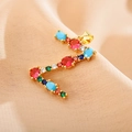 Macro detail of letter E pendant featuring colorful cubic zirconia on gold metal - Letter Z
