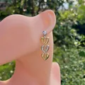 Detail of 18k gold plated heart drop earrings with tiered mixed metal link design - Triple Heart Dangle Style (Gold 3)
