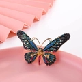 Elegant gold butterfly brooch with colorful rhinestones on a decorative pink tray - Multicolor Rhinestone Butterfly