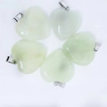 Detalle macro de cinco colgantes de cristal en forma de corazón verde claro con cierres - Aventurina Verde