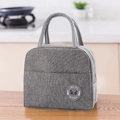 Close-up of gray insulated lunch bag with panda logo on a wooden kitchen table - Gray