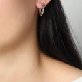 Pendientes de corazón plateados minimalistas lucidos por una modelo con estilo elegante - Color Acero