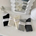 Dettaglio di cinque paia di calze di cotone a coste con uno specchio bianco minimalista - Bianco Sporco