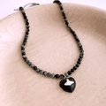 Vista de primer plano del collar de cuentas con colgante de corazón negro y logo de saturno - Colgante De Corazón Negro - Cuentas De Piedra Facetadas En Negro Y Gris (项链-黑色-土星)