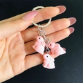 Portachiavi con coniglio in resina rosa tenuto in mano con tre ciondoli e anelli d'argento - Rosa