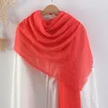 Coral red crinkled cotton linen scarf with frayed tassel edges on a wooden hanger - Coral