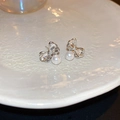 Detalle de pendientes de lazo plateados con circonitas y perlas elegantes sobre cerámica - Pendientes de Perla con Lazo Plateado (Pin de Plata)