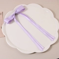 Elegant purple satin ribbon bow hair clip with long streamers on a white ceramic plate - Purple