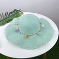 Detailed view of mint green straw sun hat featuring wavy edges and colorful tassels - Aqua Green