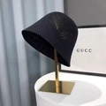 Chic black knitted bucket hat with breathable weave pattern on a gold display stand - Honeycomb Style / Black