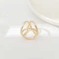 Macro shot of minimalist triple-intertwined gold ring on a white ceramic tray - BZ238-1 Gold 3-Ring Geometric Triangle