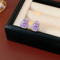 Dettaglio ravvicinato di orecchini a cuore in argento con gemma viola brillante - Ago d'Argento-Argento-Viola