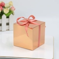 Rose gold mirror finish square candy gift box with pink ribbon bow on a white plate - Rose Gold