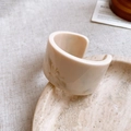 Close-up of wide open resin bangle with cream marble pattern on stone tray - 13# Bangle-Cream White-Round