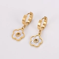 Detailed macro view of golden flower petal earrings with white floral inlay charms - Hollow Flower