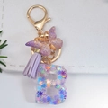Macro detail of alphabet B keychain with glitter snowflakes and purple butterfly charm - Letter B