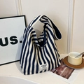 Navy and off-white striped canvas tote bag with ROSTORY CHILD label in a lifestyle setting - Blue