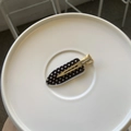 Top-down view of a black polka dot hair clip on a white plate with golden metal clip detail - Black Polka Dot Simple Style (HDJ-11) / Silver Traceless Clip / Silver