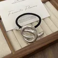 Minimalist silver metal knot hair tie with black high-elastic band on a jewelry tray - GD439 Silver Smooth Knot