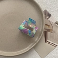 Macro shot of square hair claw clip with colorful marble texture on a beige dish - Fantasy Blue