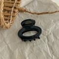 Detail of black resin oval hair claw clip with golden France Handmade lettering - Black