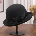 Detail von Wollhut mit eleganter Satinschleife und handgemachter Blume auf Holztisch - M (56-58cm) / Schwarz