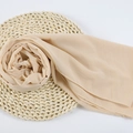 Beige chiffon hijab scarf for women displayed on a round woven straw mat background - 105