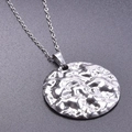 Dettaglio ravvicinato di un ciondolo tondo in acciaio argento con trama martellata irregolare - Collana Con Ciondolo / Color Acciaio