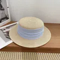 Classic beige woven boater hat with a light blue pleated ribbon on a wooden table - M / Beige with Blue Ribbon
