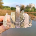 Macro view of a moon goddess hair clip with colorful crystal stones and wire-wrapped detail - Chakra Stone + Moon
