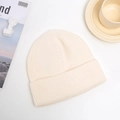 Detailed texture of thick cream knitted beanie hat with fold-over cuff for winter - One Size / Off White