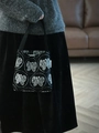 Dettaglio del ricamo a farfalla vintage su una mini borsa a spalla in tela nera - Ricamo a Farfalla