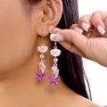 Longues boucles d'oreilles marines avec étoile de mer et perles sur l'oreille - Étoile de mer violette coquillage