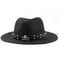 Macro detail of black straw fedora featuring a skull and rivet studded belt band - Black