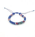 Close-up of handmade woven surfing bracelet with blue bohemian ethnic patterns and tassels - Size 17