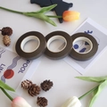 Three rolls of dark brown floral tape for crepe paper flowers on clean white background - 03 Coffee
