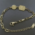 Detalle de una pulsera de acero dorado con disco Lucky y colgante de personaje animado - Dorado