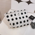Détails d'une trousse à maquillage tissée blanche à pois noirs avec étiquette en tissu - Blanc à pois noirs