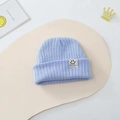 Light blue knit baby beanie with a smiley patch and warm ribbed winter texture - One Size / Blue