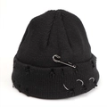 Detailed view of black distressed knit beanie with silver safety pin and metal rings - Black